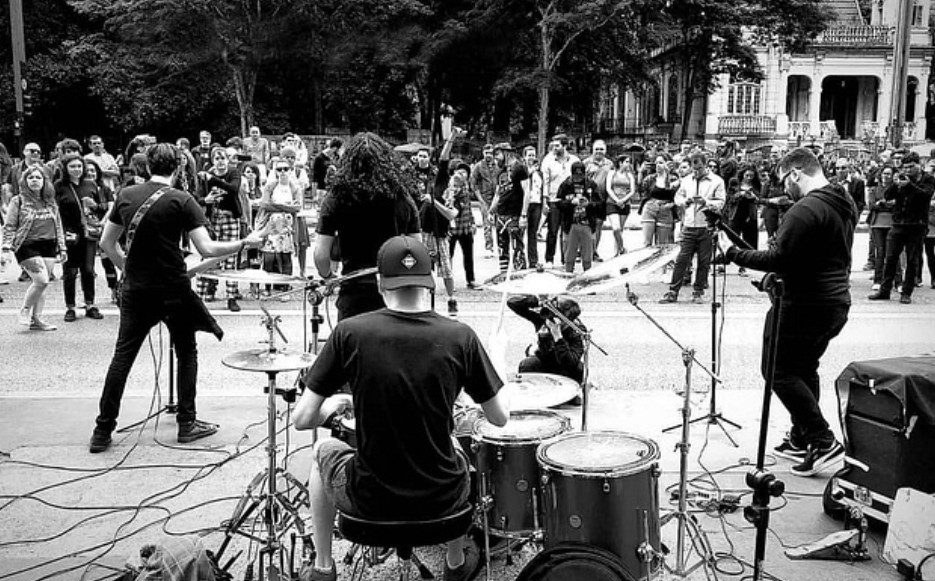 Show ao ar livre em preto e branco, com o público ao redor